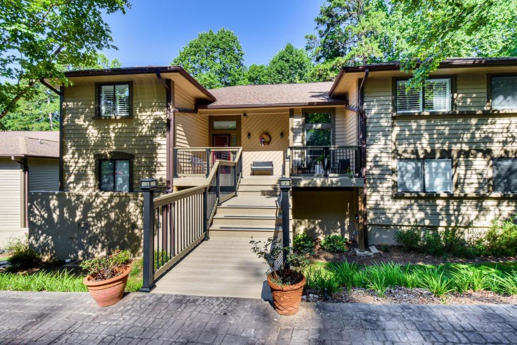 Two-story home with clean tan siding, wooden walkway, and spotless windows