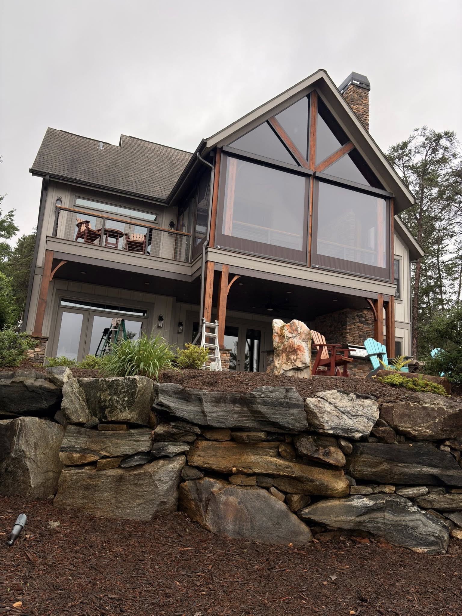 Large home with floor-to-ceiling windows and cleaning ladders on site